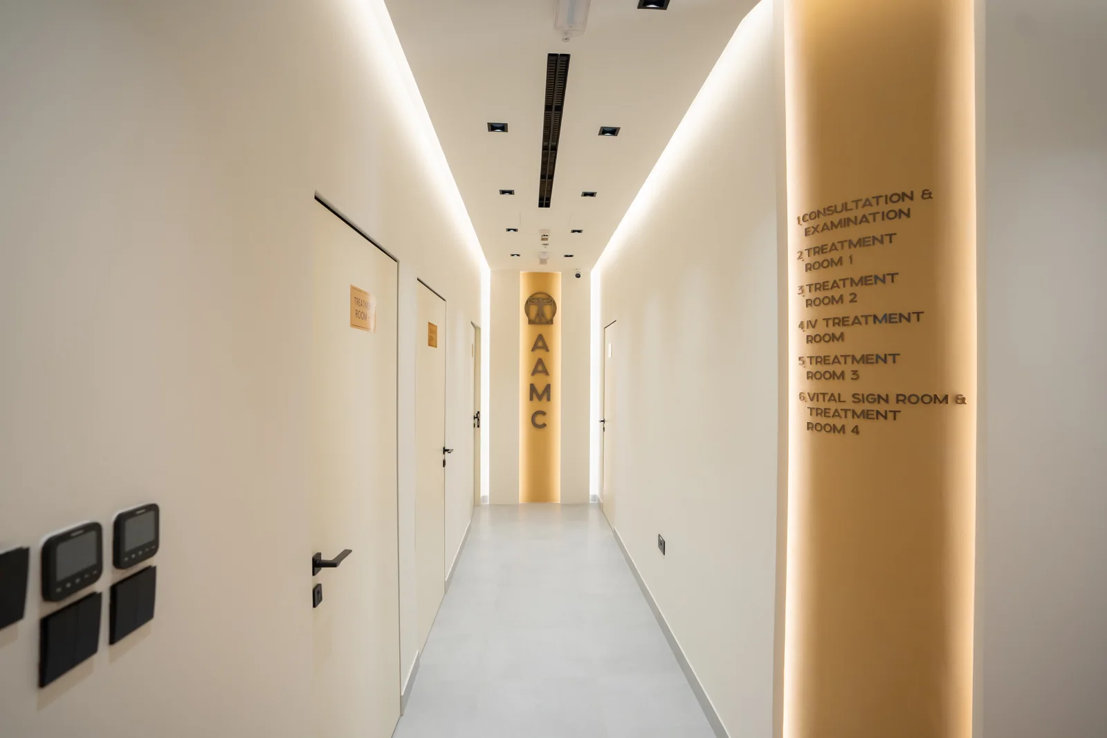 Illuminated clinic corridor with room wayfinding at AAMC Polyclinic